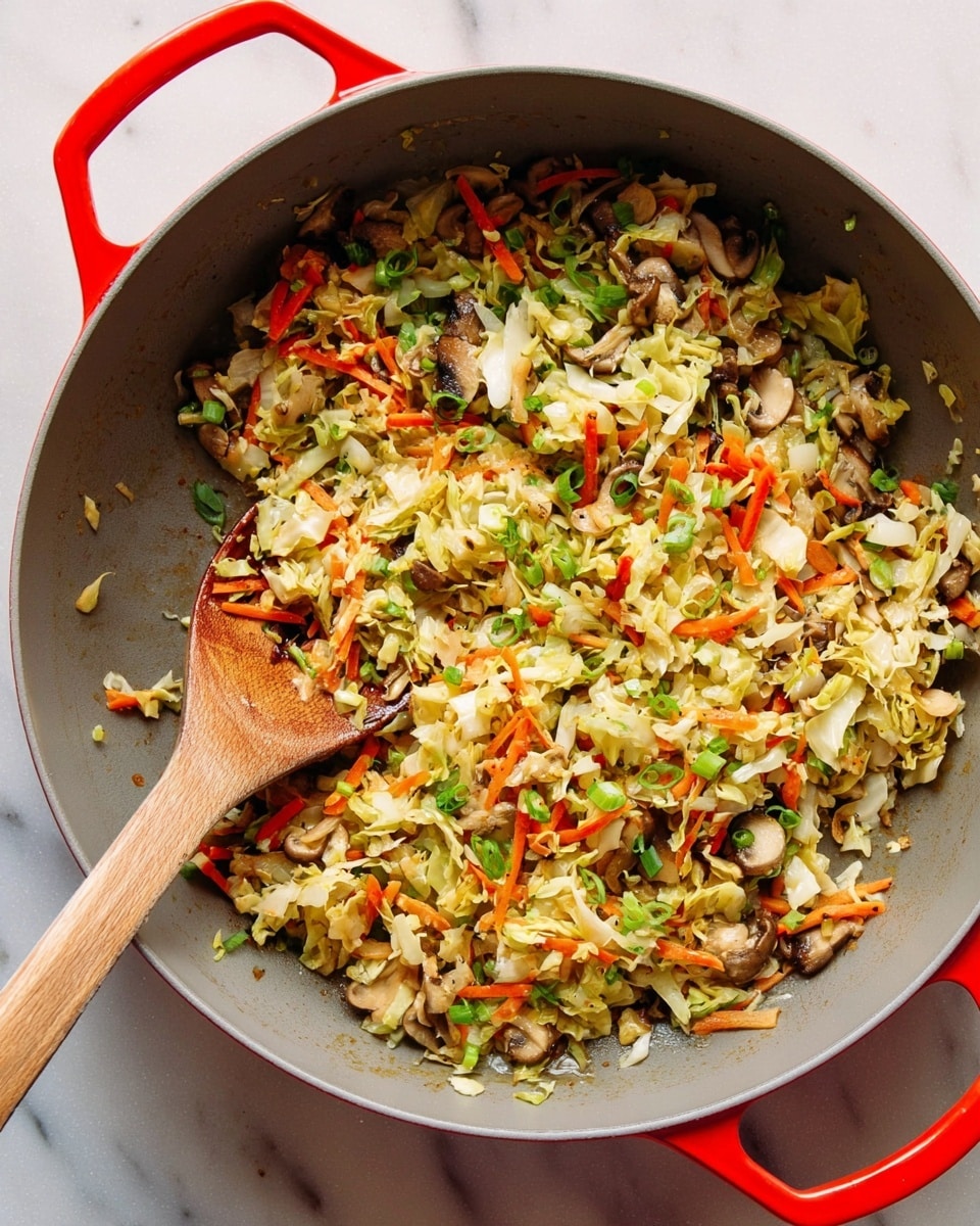 A large gray pan with bright red handles is filled with a mixture of cooked vegetables including finely chopped mushrooms, shredded light green cabbage, thin orange carrot strips, and sliced green onions. The vegetables appear lightly sautéed, showing a mix of soft and slightly crispy textures. Inside the pan, a wooden spoon rests on the left side, partially covered by the vegetable mix. The background is a white marbled surface. photo taken with an iphone --ar 4:5 --v 7