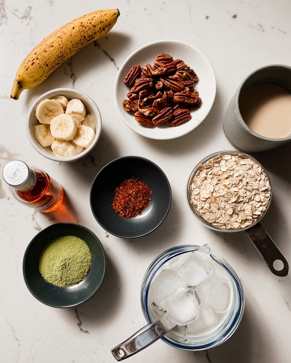 The image shows a top view of various ingredients arranged neatly on a white marbled surface. There is a white bowl with peeled bananas on the left side, next to a small white plate filled with rolled oats. Above that is a small white bowl holding dark brown pecans. In the center, there are two small black bowls: one with a bright green powder and another with a mix of reddish-brown and white spices. On the right side, a silver measuring cup contains a white, creamy substance, and a clear plastic scoop filled with light brown powder is placed nearby. Beside these is a small amber bottle of vanilla extract and part of a white bowl with a blue rim filled with ice. A gray mug with a beige liquid is also visible at the top right corner. The setup is clean and well organized, with soft lighting highlighting the textures of the ingredients. Photo taken with an iphone --ar 4:5 --v 7