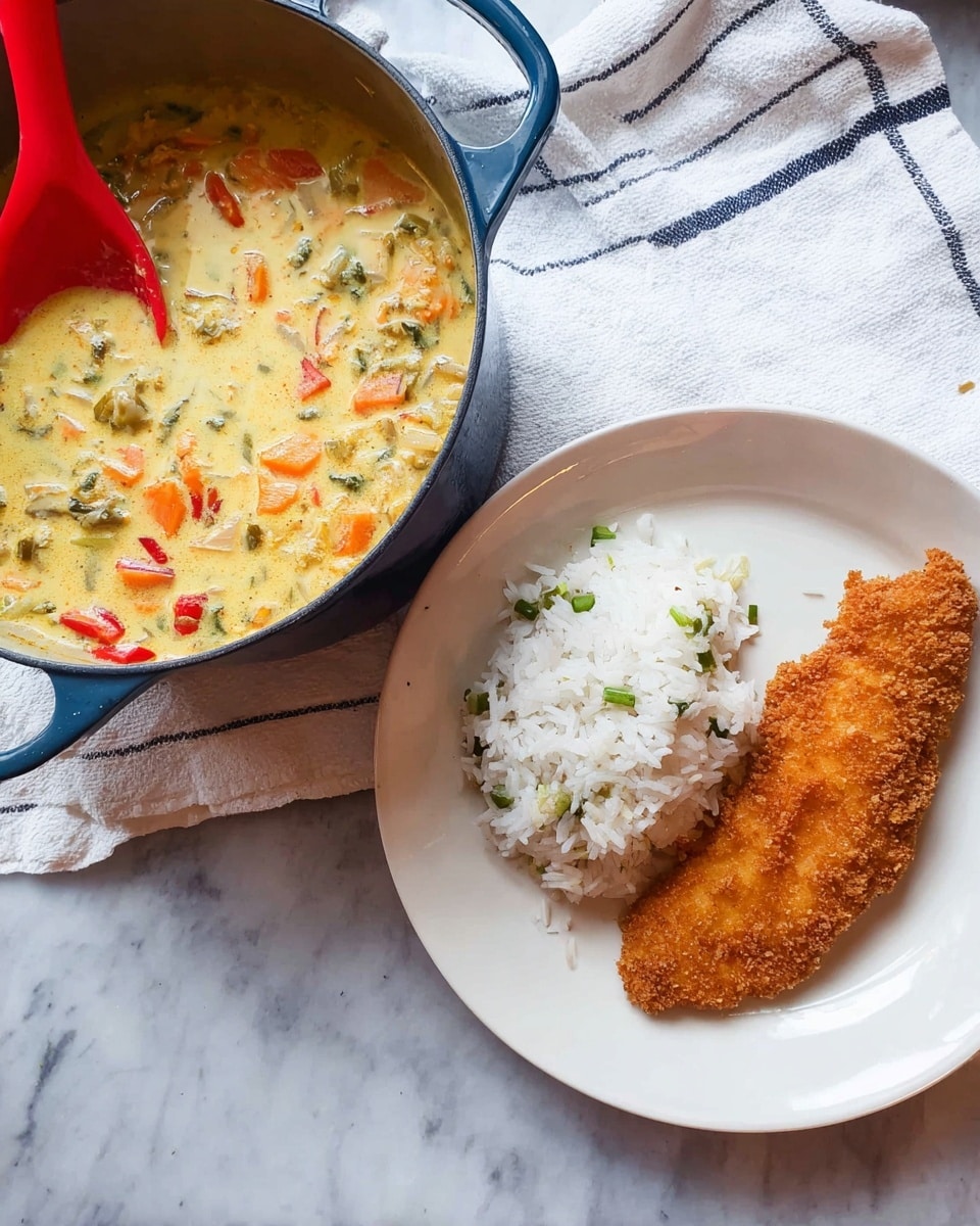 A white round plate holds a golden brown crispy fried fish fillet on the right side, with a small mound of white rice mixed with small green pieces on the left side. Next to the plate is a large blue cast iron pot filled with a creamy, light yellow soup containing chunks of orange carrots, green vegetables, and bits of red pepper. A red spatula rests inside the pot. Both items sit on a white marbled surface with a white cloth featuring thin dark stripes placed casually underneath the pot. Photo taken with an iphone --ar 4:5 --v 7