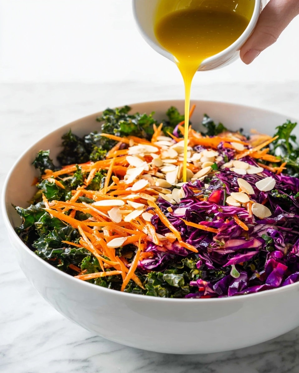 A large white bowl filled with a colorful salad shows several layers: the bottom layer consists of dark green kale leaves with a rough texture, mixed with bright purple shredded cabbage that adds depth and color; on top of this are thin orange carrot strips scattered evenly throughout, adding brightness, and thin white almond slices spread across the salad for light contrast. Above the bowl, a woman's hand is pouring a golden yellow dressing that flows smoothly into the salad. The scene is set against a white marbled surface that highlights the vibrant colors of the fresh vegetables. photo taken with an iphone --ar 4:5 --v 7