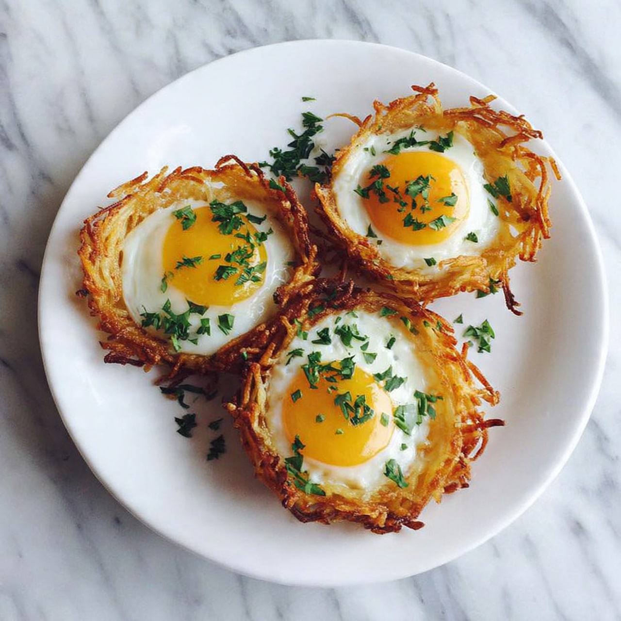 The image shows five small round nests made from thin crispy golden-brown strands forming the outer layer, each filled with a melted yellow cheese topping that covers the surface smoothly. The nests are garnished with small green herb leaves scattered on top. They are arranged neatly on a white plate, which sits on a piece of light brown burlap fabric, all set against a white marbled surface. The overall look is warm and inviting with a combination of crunchy texture from the nests and smooth melted cheese on top. photo taken with an iphone --ar 4:5 --v 7