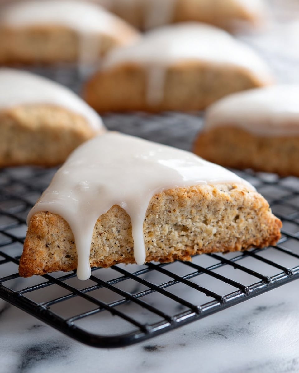 The image shows a baking tray with a black cooling rack placed on a white marbled surface. On the rack, there are twelve triangle-shaped scones arranged in a loose pattern. Each scone has a thick, light brown base with a rough texture and is topped with a smooth, white icing layer that evenly covers the top surface. The lighting is bright, highlighting the soft and crumbly texture of the scones, with slight golden edges visible on some pieces. The overall look is clean and simple, focusing on the contrast between the warm scones and cool white icing. photo taken with an iphone --ar 4:5 --v 7
