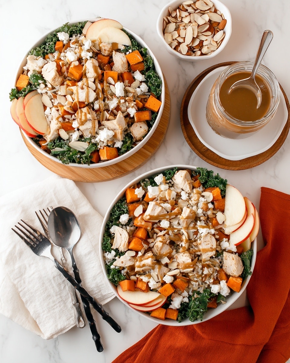 Two white bowls on a white marbled surface hold fresh salads with multiple layers. The bottom layer is green kale leaves, topped with small chunks of light brown grilled chicken, scattered orange cubes of roasted sweet potatoes, and light brown cooked rice. There are also thin slices of red apple with white flesh placed on the sides of each bowl. Small white dollops of cottage cheese are spread across the bowls, with slivered almonds sprinkled on top. A brown dressing is drizzled over the salad. Nearby, there is a small white bowl filled with slivered almonds and a glass jar with brown dressing and a spoon inside, placed on a white saucer atop an orange cloth. A wooden board holds the lower bowl, which rests on a white cloth napkin next to two black forks with swirled handles. Photo taken with an iphone --ar 4:5 --v 7