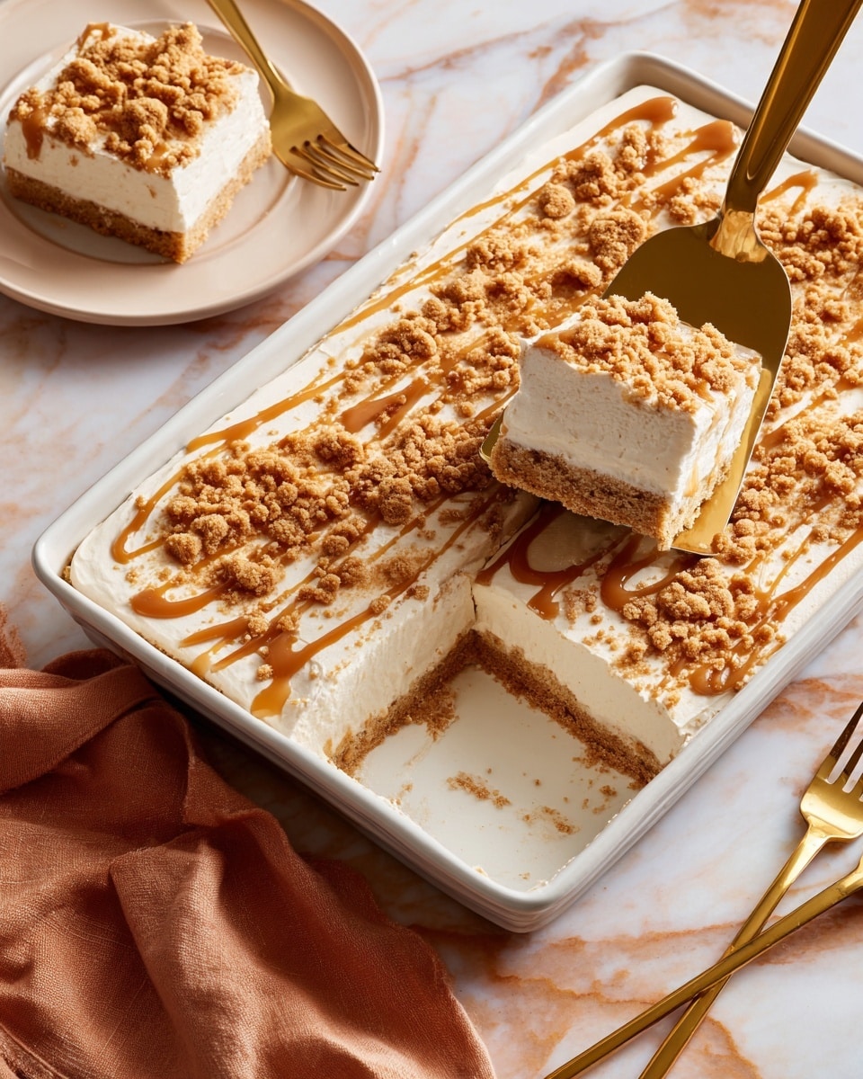 A large white rectangular pan holds a dessert with three visible layers: a light beige soft cake base, a thick white creamy middle layer, and a topping of golden brown crumbly pieces spread around the edges and drizzled with smooth caramel sauce across the top. A square piece of the dessert is lifted above the pan on a golden spatula, showing the layers clearly, while another square piece sits on a white plate nearby with a golden fork resting beside it. The scene is set on a white marbled surface with a soft orange cloth partially visible in the corner. Photo taken with an iphone --ar 4:5 --v 7