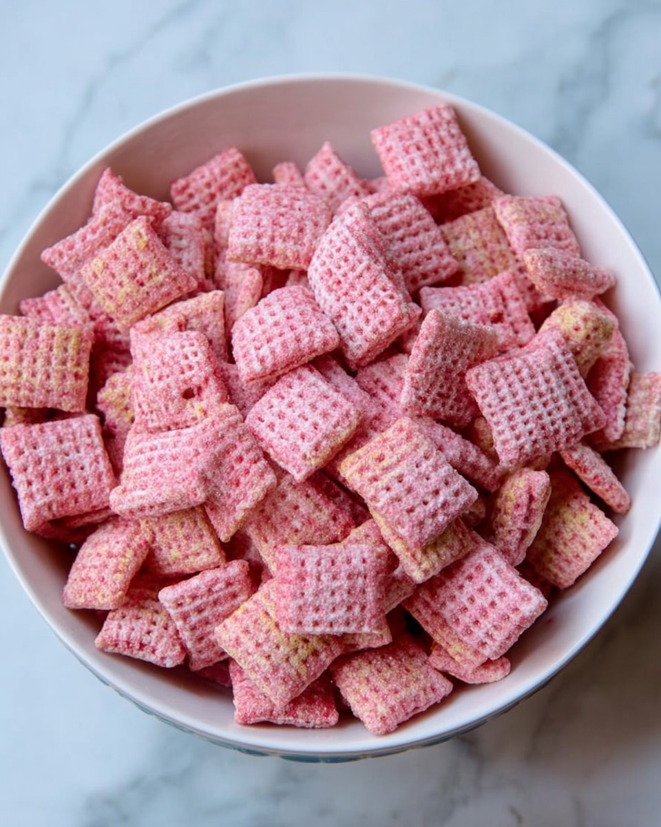 A white bowl filled with many square cereal pieces that are light pink in color. Each cereal piece has a grid texture with small holes and a slightly powdery surface. The bowl sits on a white marbled surface. The cereal pieces fill the bowl fully and are piled unevenly, showing some depth and layers of the cereal inside. Photo taken with an iphone --ar 4:5 --v 7