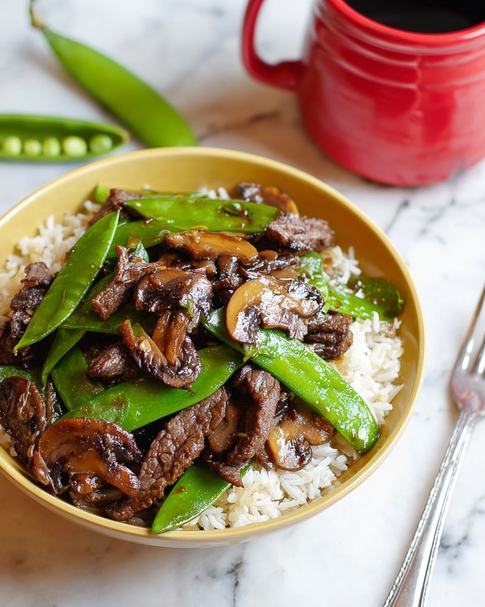 A white bowl filled with two layers: the bottom layer is plain white rice, and the top layer consists of brown cooked beef slices mixed with green snow peas and brown sliced mushrooms with a shiny sauce. Next to the bowl is a silver fork on a white marbled surface, and in the background is a red mug and a green snow pea pod. Photo taken with an iphone --ar 4:5 --v 7