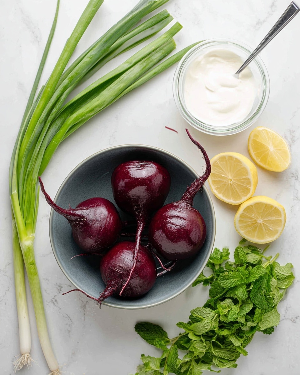 A bowl filled with four whole cooked beets, dark red and shiny with stems attached, sits in the center on a white marbled surface. Above the bowl is a clear glass container containing a smooth white sauce with a spoon inside. To the left, there are fresh green onions with long green stems and white bulbs, placed diagonally. On the right side, two halves of a bright yellow lemon sit near bunches of fresh green parsley and mint leaves. The overall setup is clean and fresh with natural, vibrant colors. photo taken with an iphone --ar 4:5 --v 7