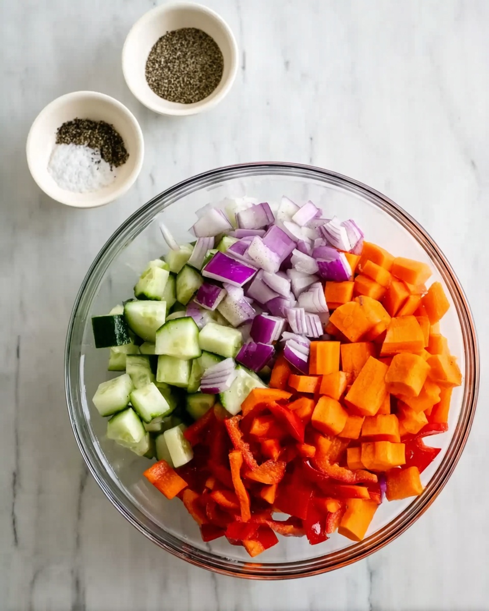 A clear glass bowl filled with chopped vegetables on a white marbled surface. The vegetables are layered with orange carrot sticks on the bottom right, pale green cucumber chunks in the middle, bright red bell pepper pieces scattered around, and purple onion wedges mixed throughout. Behind the bowl, there are two small white bowls, one containing coarse black pepper and the other coarse salt. A woman's hand is reaching toward the bowl from the right side. photo taken with an iphone --ar 4:5 --v 7