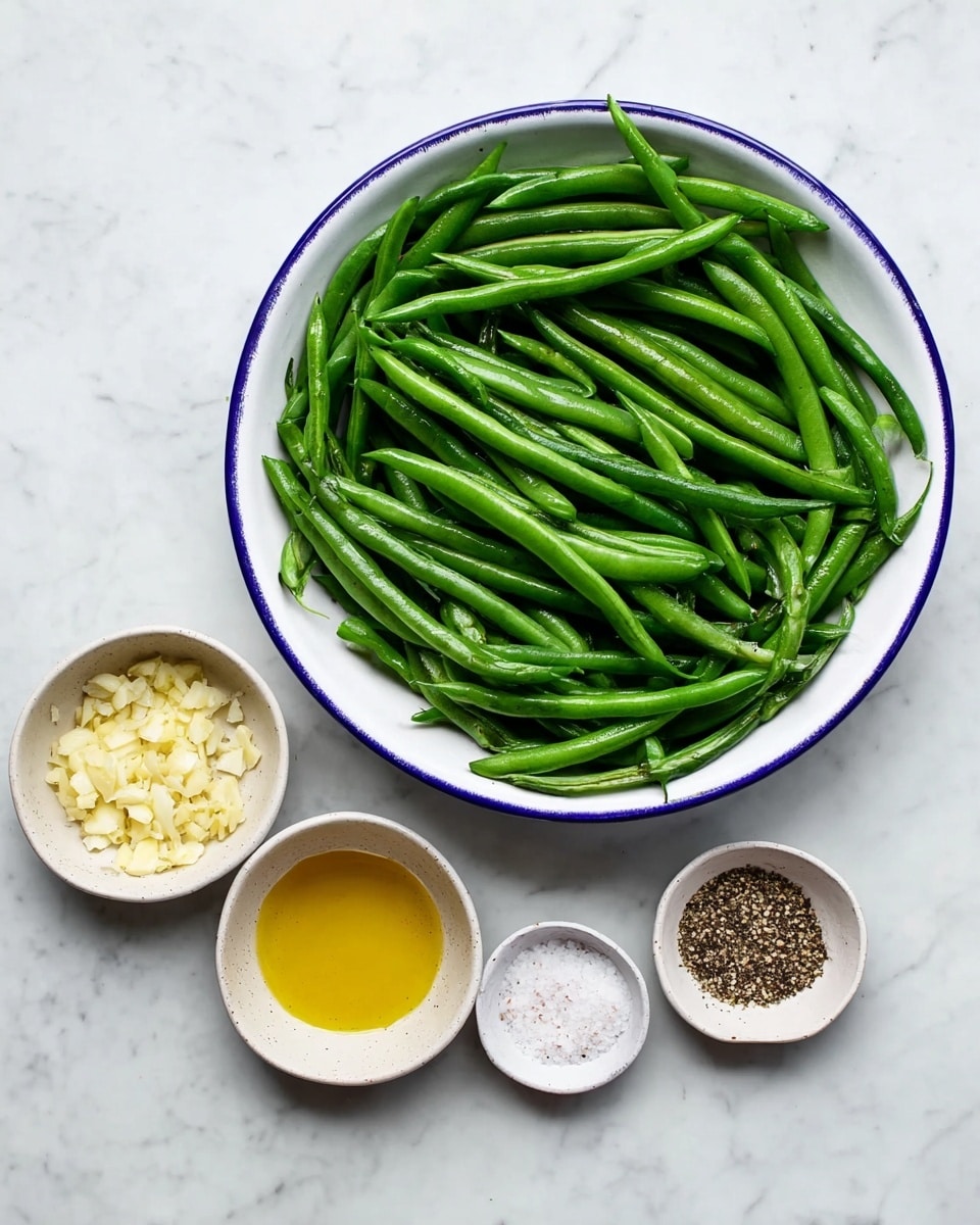 A large white bowl with blue edge is filled with fresh bright green beans that lie in random directions, showing their smooth and firm texture. Surrounding the bowl are four small white bowls placed on a white marbled surface: one holds finely chopped pale yellow garlic, another contains a golden yellow oil, the third has coarse white salt, and the last one is filled with crushed black pepper, presenting a variety of colors and textures for seasoning. photo taken with an iphone --ar 4:5 --v 7