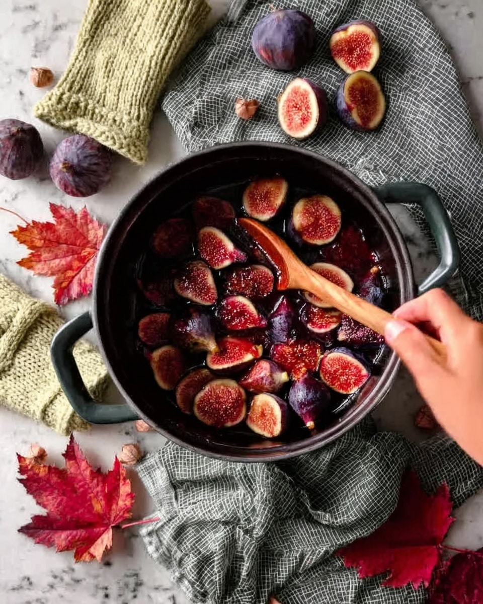 A close-up top view of a pot filled with many pieces of fresh figs, dark purple outside with red and pink inside, being stirred by a woman's hand holding a wooden spoon. The pot is black with a shiny surface, resting on a white marbled textured surface. Around the pot, there are whole figs, some cut open, showing their red interior, along with red autumn leaves and knitted gloves in soft green and cream colors. A gray checkered cloth lies near the pot. The scene gives a cozy, autumn feel with many warm colors. photo taken with an iphone --ar 4:5 --v 7