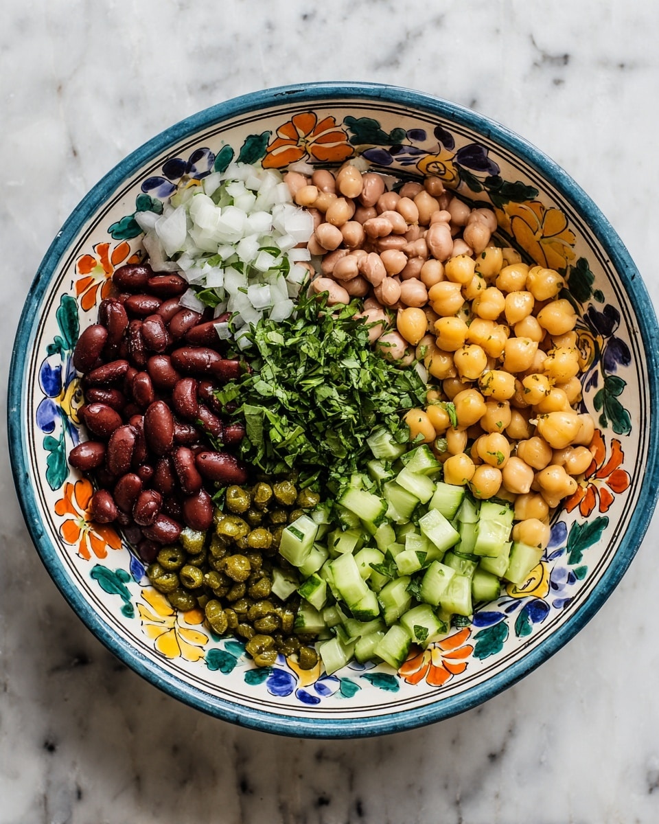 A white bowl with blue, orange, and yellow floral patterns is filled with six visible layers of ingredients arranged side by side. From left to right, the first layer is dark brown beans with a shiny, smooth texture; next to it are small white chopped onions; the third layer is light brown beans with a soft texture; in the middle, there is a heap of bright green chopped herbs; following that is a cluster of yellow chickpeas with a round shape; and the last section shows bright green cucumber pieces cut into small chunks with visible seeds. Small green capers are scattered on top of the onions, herbs, and cucumber pieces. The bowl sits on a white marbled surface photo taken with an iphone --ar 4:5 --v 7